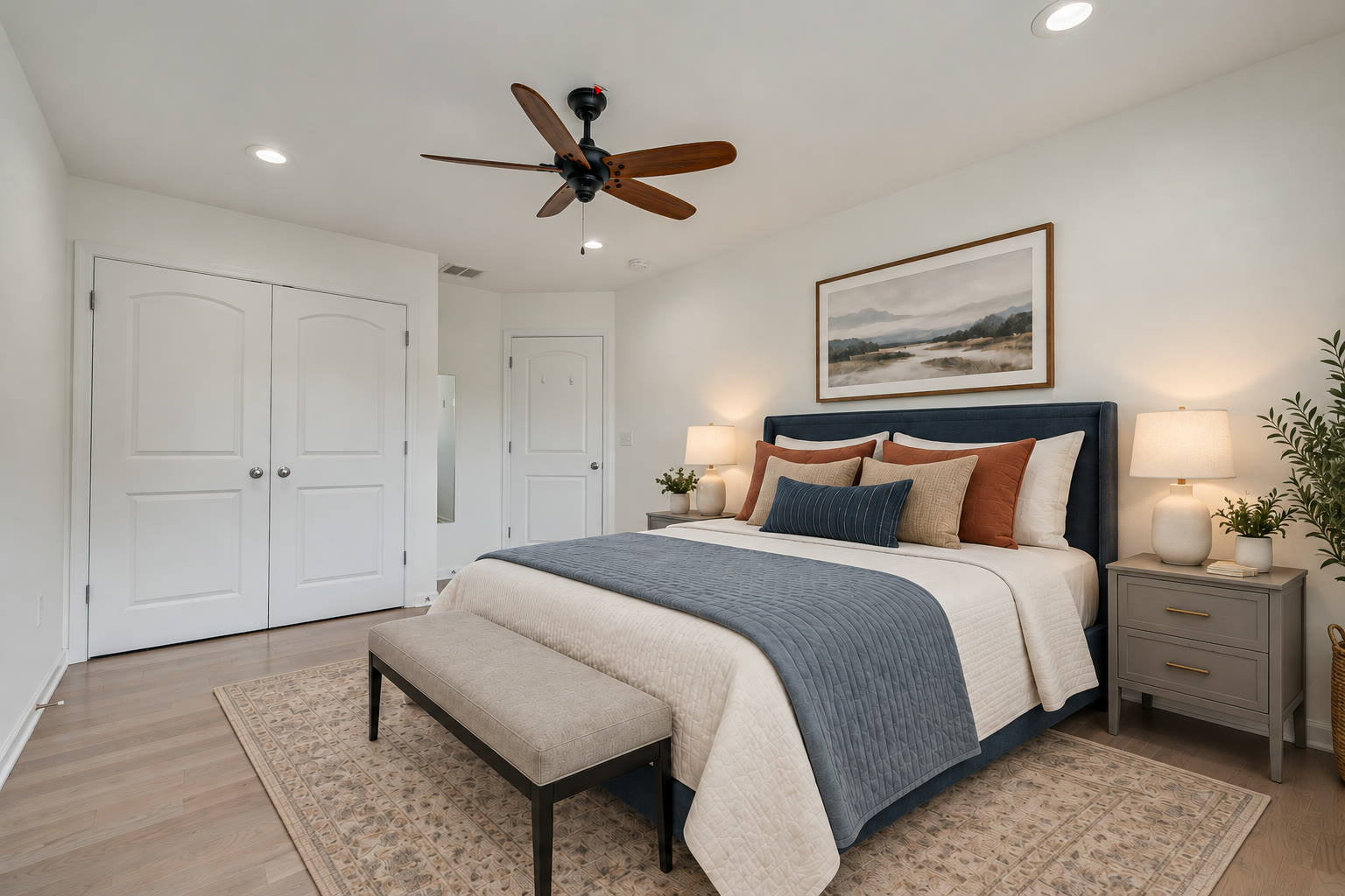 Fourth bedroom with a navy upholstered bed and double closet doors